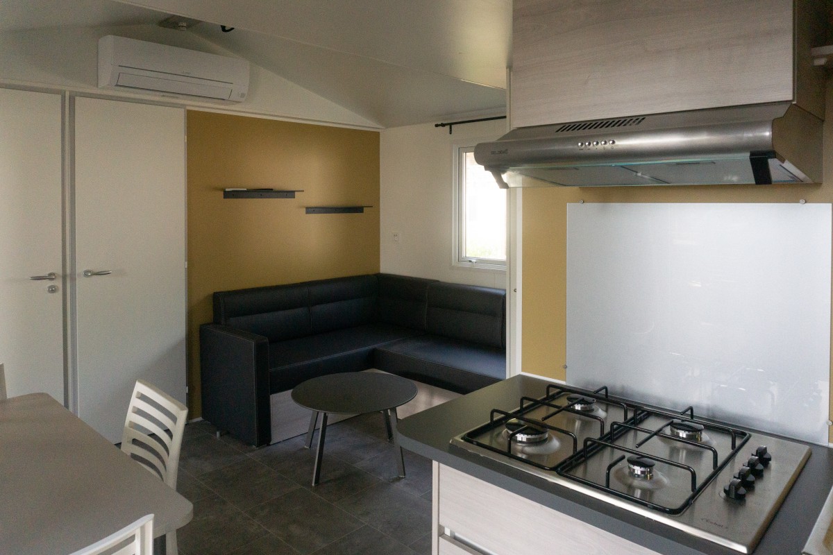 Pièce à vivre du mobil home neuf 2 chambres TRIGANO Evo 29 sur parcelle en camping