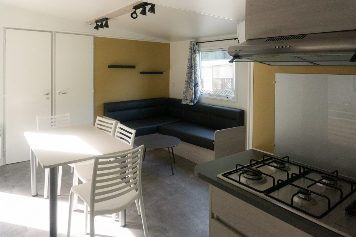 Pièce à vivre du mobil home neuf 2 chambres TRIGANO Evo 33 sur sa parcelle en camping