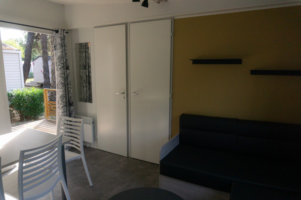 Pièce à vivre du mobil home neuf 2 chambres TRIGANO Evo 33 sur sa parcelle en camping