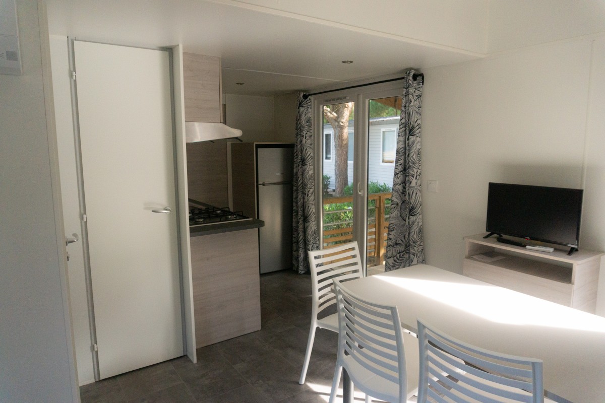 Pièce à vivre du mobil home neuf 2 chambres TRIGANO Evo 33 sur sa parcelle en camping