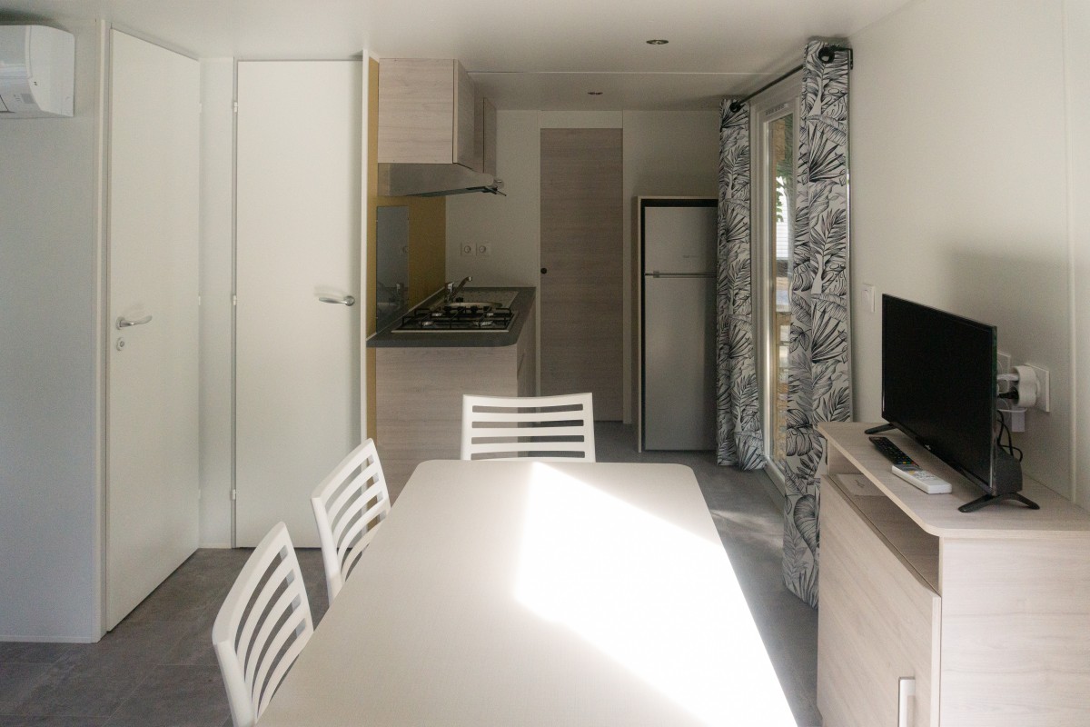 Pièce à vivre du mobil home neuf 2 chambres TRIGANO Evo 33 sur sa parcelle en camping